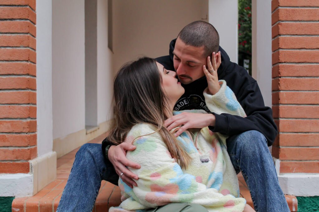 Ensaio casal se beijando em frente a uma entrada de uma porta