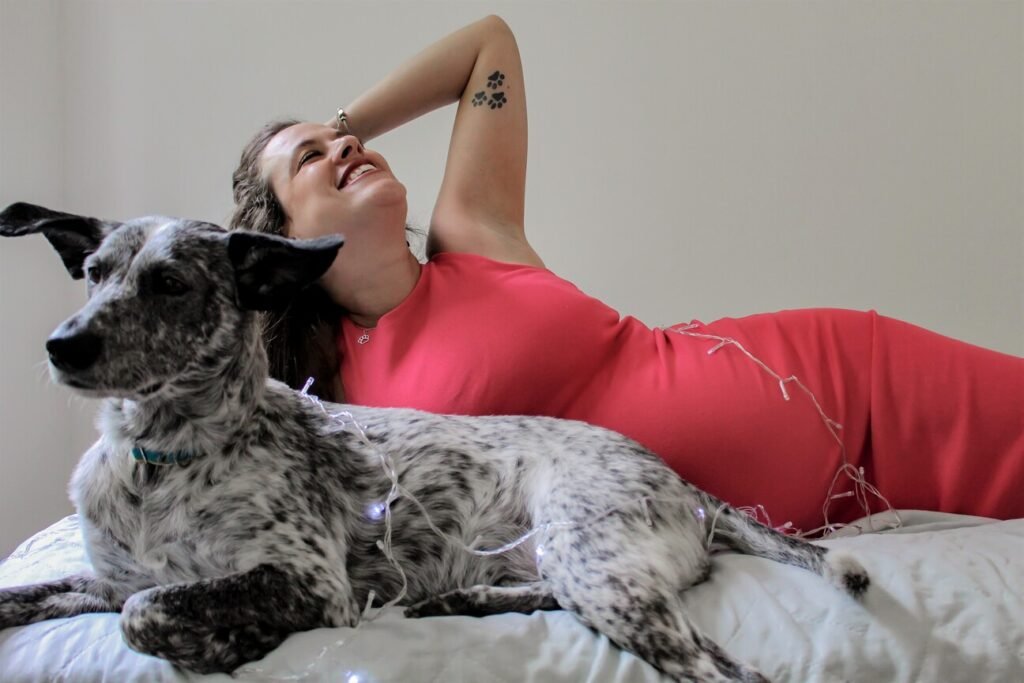 Ensaio fotográfico pet e dona do cachorro deitados na cama