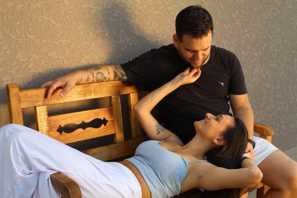 foto romantica de um casal que se entreolha sentados num banco